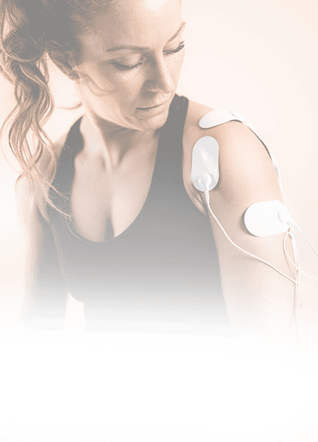 Close-up of a woman receiving electrical muscle stimulation therapy on her shoulder for pain relief and recovery, demonstrating advanced sports medicine treatment for athletes and active individuals.
