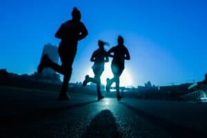 Running athletes at sunset for sports medicine and knee health.
