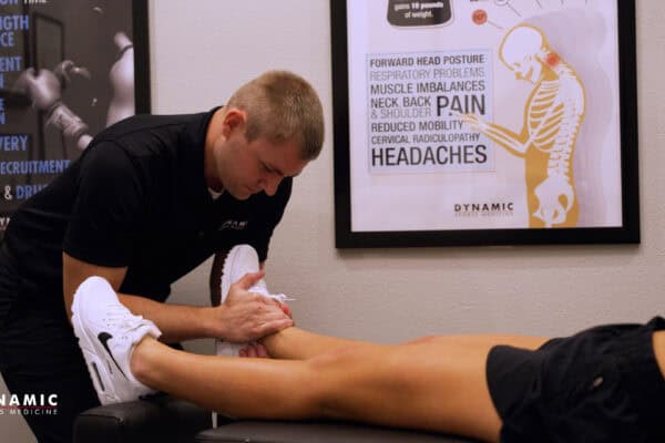 Chiropractor performing foot and ankle therapy for sports injury recovery at Dynamic Sports Medicine.