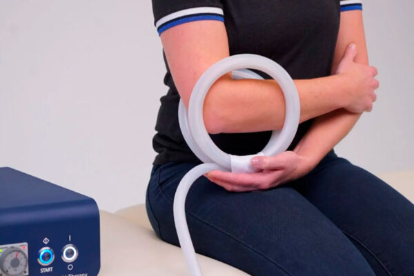 PEMF therapy device with coil applicator wrapped around a patient's elbow during treatment session.