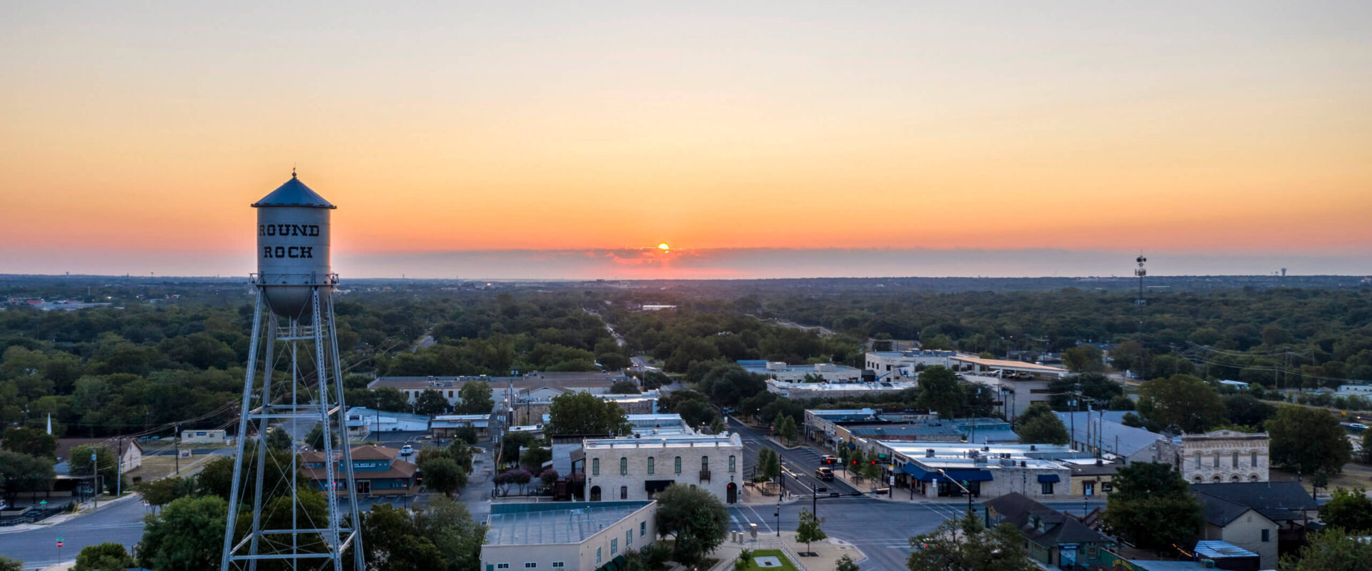Aerial view of the historic Round Rock water tower and downtown Round Rock, Texas at sunset